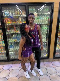 a man and woman standing in front of refrigerators with drinks on display behind them