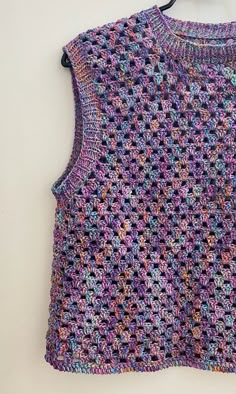 a crocheted top hanging on a wall