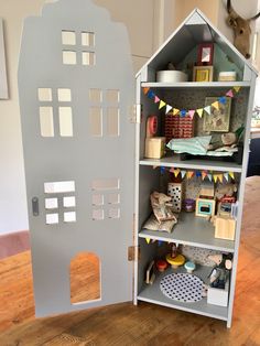 a doll house made out of cardboard on a wooden floor