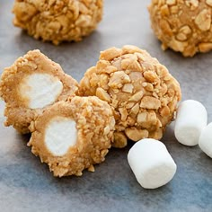 marshmallows and cookies are arranged on a baking sheet to look like snowballs