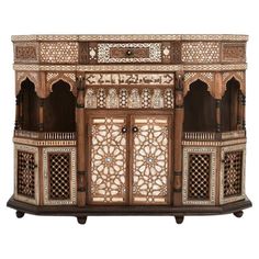 an intricately carved wooden cabinet with carvings on the doors and drawers, inlaid to wood