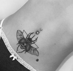 a black and white photo of a bug on the back of a woman's stomach