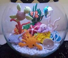 an aquarium filled with crocheted sea animals and corals on top of rocks