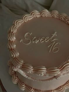 a close up of a frosted cake on a plate with the words sweet 16