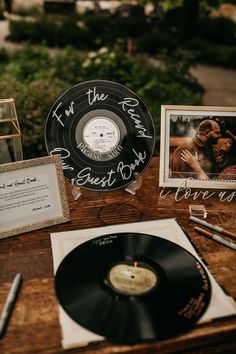 an old record sits on a table next to other items that include cards, photos and pens