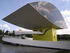 a large yellow and white structure sitting next to a body of water