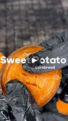 an orange is wrapped in black plastic and has the words sweet potato on it