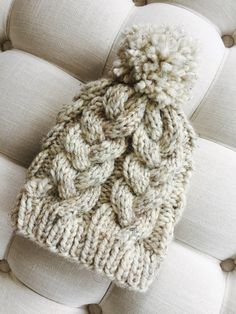 a knitted hat sitting on top of a white couch