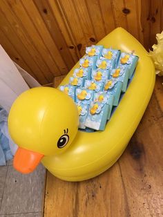 an inflatable rubber ducky with baby blocks on it's back sitting next to flowers