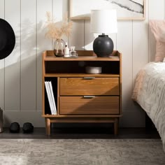 a bedroom scene with focus on the nightstand and bed side table in the foreground