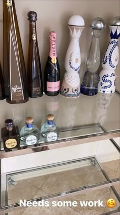 there are many different types of bottles on the shelf next to each other, and one has a message that says needs some work