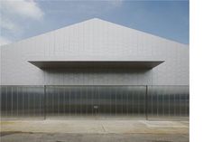 an empty parking lot next to a large white building