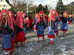 several people dressed in red and blue are walking down the street with polka dots on their heads