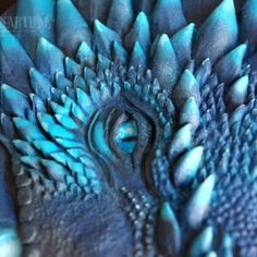 a close up view of the eye of a blue bird's head and feathers