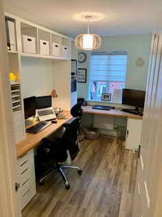 an office area with desk, computer and shelves