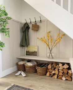 there is a shelf with baskets and firewood in the corner next to some stairs