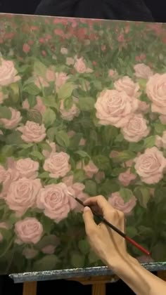 a person is painting flowers on an easel