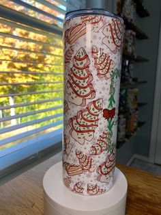 a christmas themed tumbler sitting on top of a counter next to a window with blinds