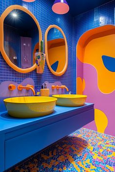 two yellow sinks are in front of colorful mirrors