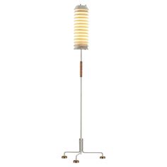 a floor lamp that is on top of a metal stand and has a white light in the middle