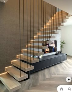 there is a tv on the wall next to some stairs in this living room with wood flooring