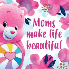 a pink teddy bear sitting on top of a flower covered field with the words moms make life beautiful