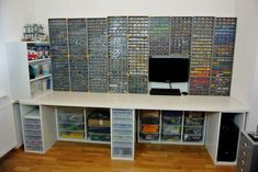 a computer desk with lots of drawers and shelves on the wall next to each other