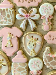 baby shower cookies decorated with giraffes, ones, and other items on a table