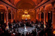 a bride and groom standing on the dance floor at their wedding reception in an old church