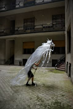 a man is walking in the street with a plastic bag on his head and an umbrella over his head