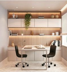 a white table with two black chairs in front of it and shelves on the wall