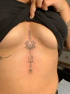 a woman's stomach with a tattoo on the lower part of her body and flowers