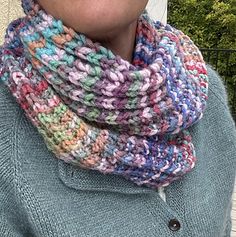 a woman wearing a multicolored knitted cowl with buttons on the side