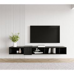 an entertainment center with a flat screen tv mounted on it's side, in front of a white wall