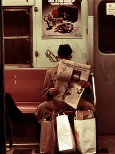 a man sitting on a train reading the newspaper