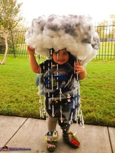 a little boy that is standing on a scooter with clouds over his head