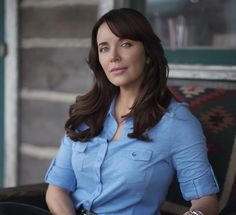 a woman sitting in a chair wearing a blue shirt