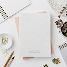 an open notebook sitting on top of a table next to other office supplies and stationery