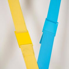 two blue and yellow belts on a white surface