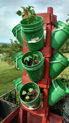 several buckets are stacked on top of each other to hold plants in the garden