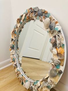 a mirror that is sitting on the floor next to a door and some seashells