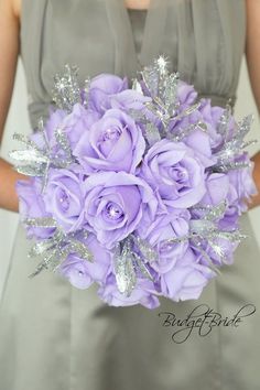 a bride's bouquet with purple roses and silver sequins is pictured in this image