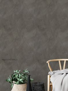 a chair next to a potted plant in front of a wall with grey walls