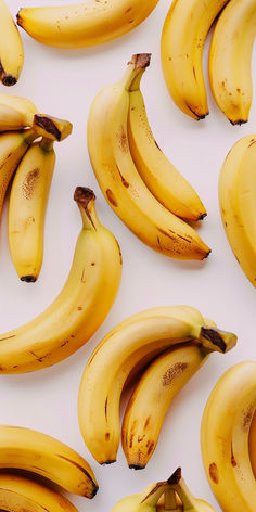 several bunches of ripe bananas on a white surface