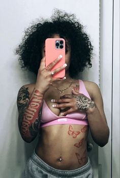 a woman taking a selfie with her cell phone in front of her face and tattoos on her stomach