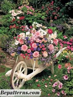 a wheelbarrow filled with lots of pink and white flowers