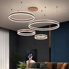 a modern living room with circular lights hanging from the ceiling and green couch in front of it