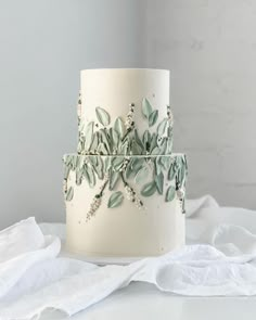 a white cake with green leaves on it