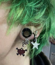 a person with green hair and piercings on their ears