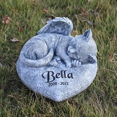 a cat figurine sitting on top of a rock with the name bella